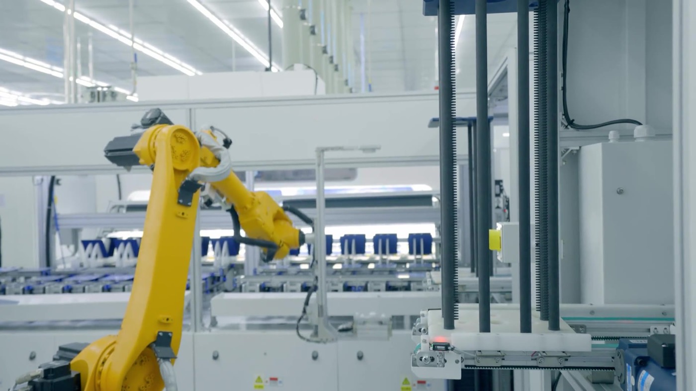 Yellow industrial robot arm working on a factory line